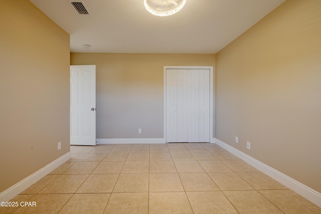 unfurnished bedroom with light tile patterned floors and a closet