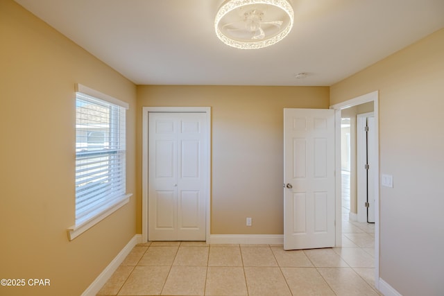 unfurnished bedroom featuring light tile patterned floors and a closet