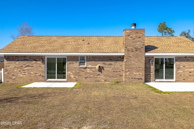 back of house with a patio and a lawn