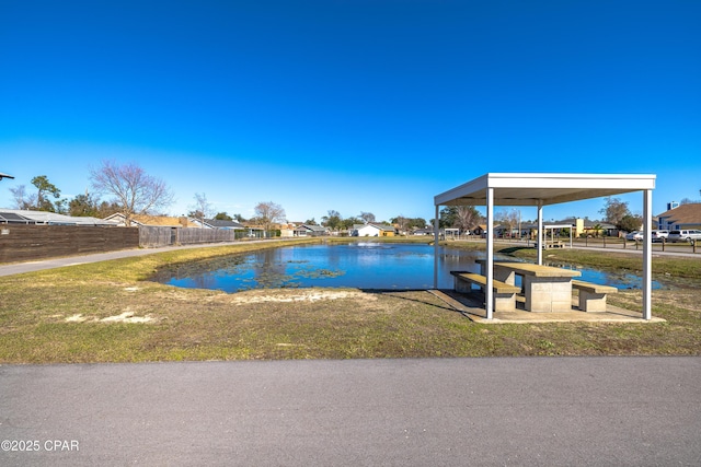 dock area with a water view and a lawn