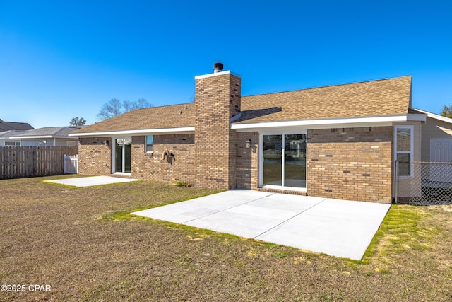 back of property featuring a patio area and a lawn