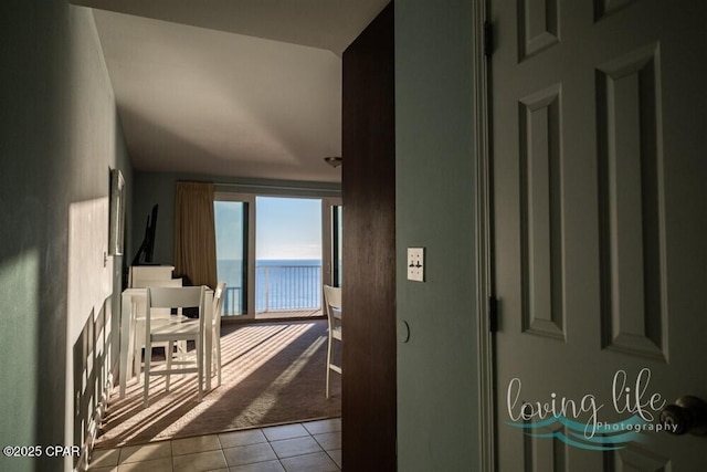 hallway with a water view and light tile patterned floors