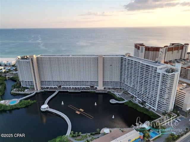 aerial view at dusk featuring a water view