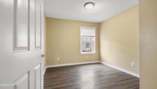 empty room featuring dark hardwood / wood-style floors and a textured ceiling