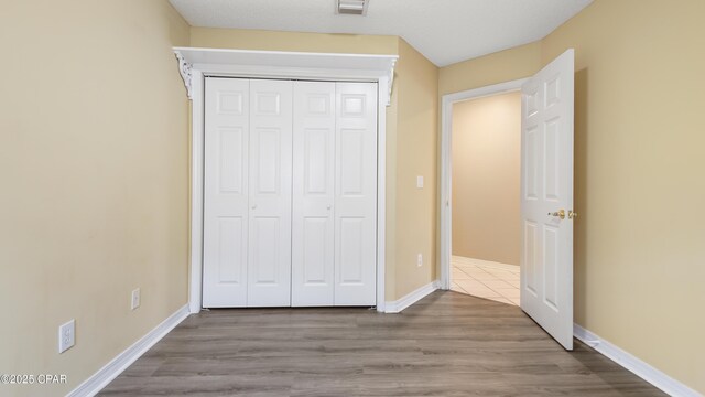 unfurnished bedroom featuring light wood-type flooring and a closet