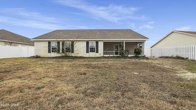 back of house with a sunroom and a yard