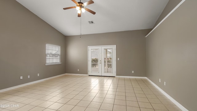 tiled empty room featuring ceiling fan, french doors, and vaulted ceiling