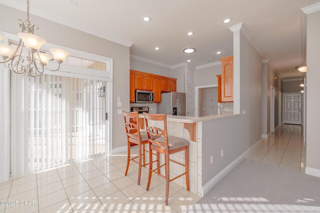 kitchen with decorative light fixtures, sink, ornamental molding, stainless steel appliances, and an inviting chandelier