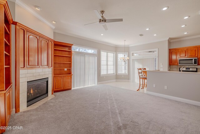 kitchen with pendant lighting, decorative backsplash, ornamental molding, stainless steel appliances, and a healthy amount of sunlight