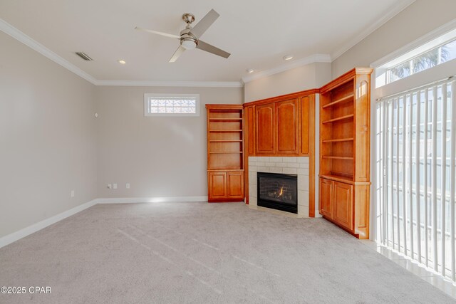 unfurnished living room featuring light carpet, crown molding, a fireplace, and ceiling fan with notable chandelier