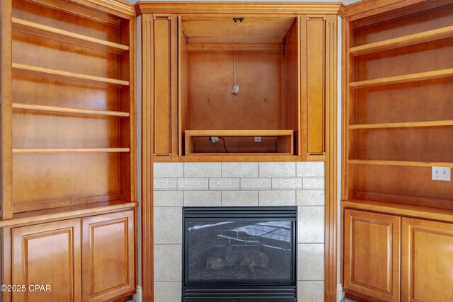 unfurnished living room with a tiled fireplace, crown molding, plenty of natural light, and light carpet