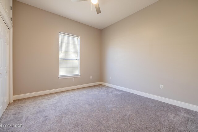 carpeted empty room with ceiling fan and lofted ceiling