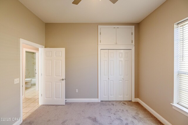 unfurnished bedroom with light carpet, a closet, and ceiling fan