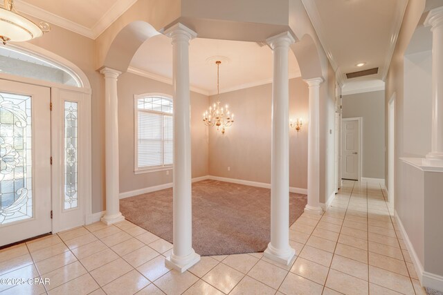 entryway featuring light tile patterned floors, crown molding, and ornate columns