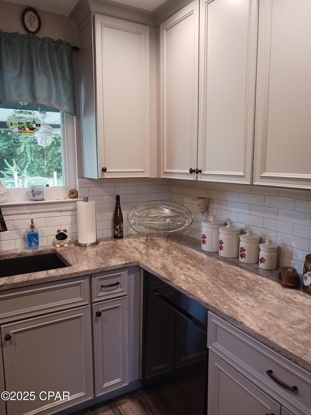 kitchen with sink, white cabinetry, and decorative backsplash