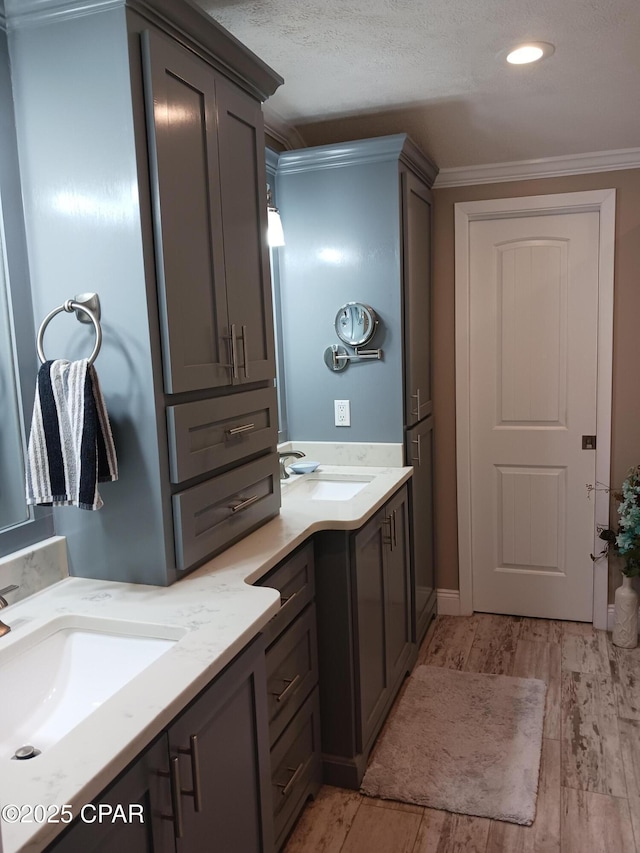 bathroom featuring ornamental molding, a textured ceiling, vanity, and hardwood / wood-style flooring