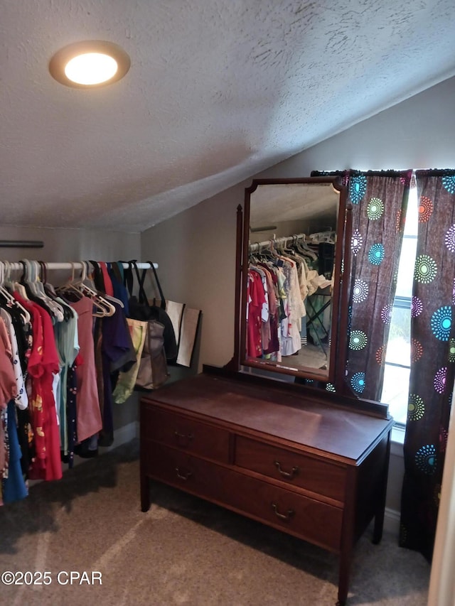 walk in closet featuring lofted ceiling and carpet