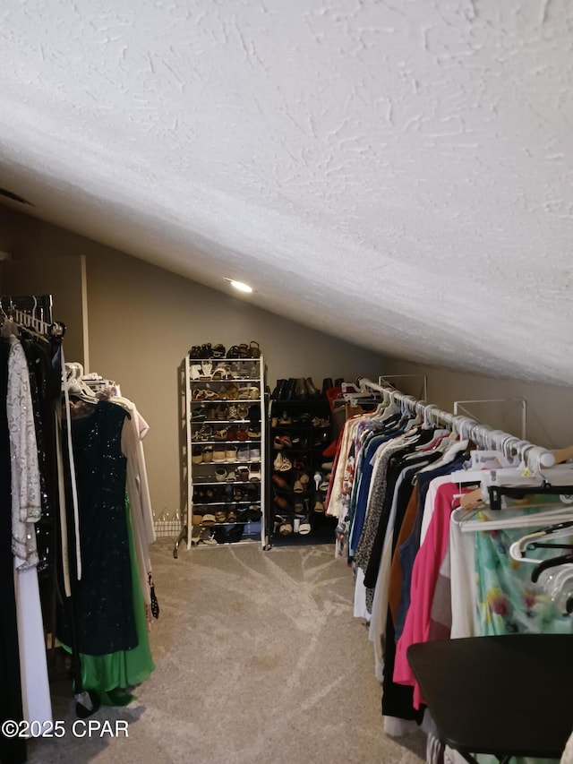 walk in closet featuring vaulted ceiling and carpet