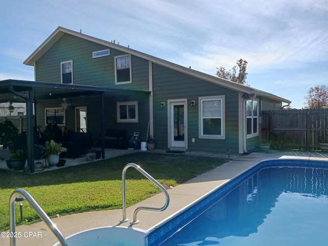 back of property featuring a patio, a fenced in pool, and a lawn