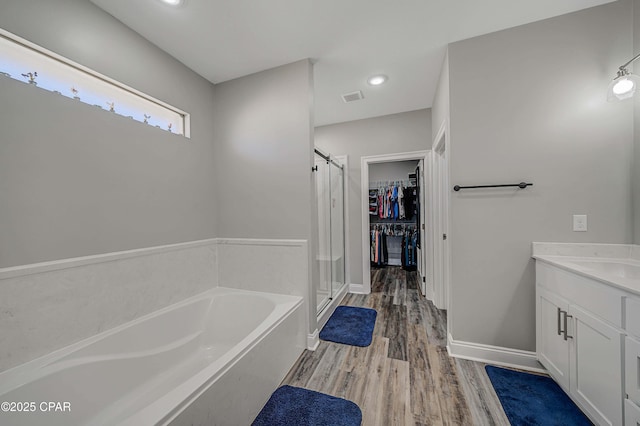 bathroom featuring vanity, shower with separate bathtub, and hardwood / wood-style floors