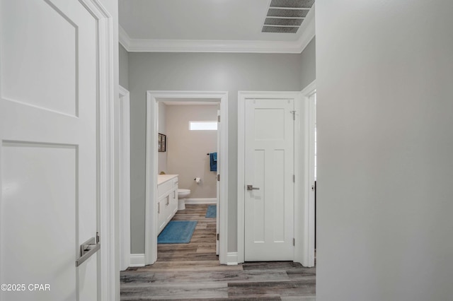 hall with crown molding and hardwood / wood-style flooring