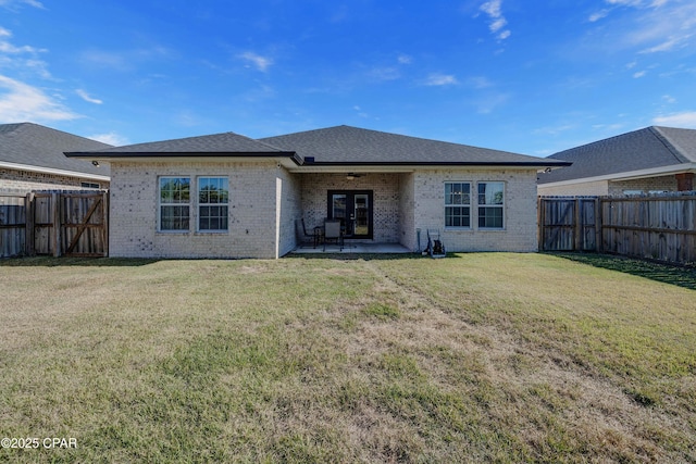 back of house with a yard and a patio