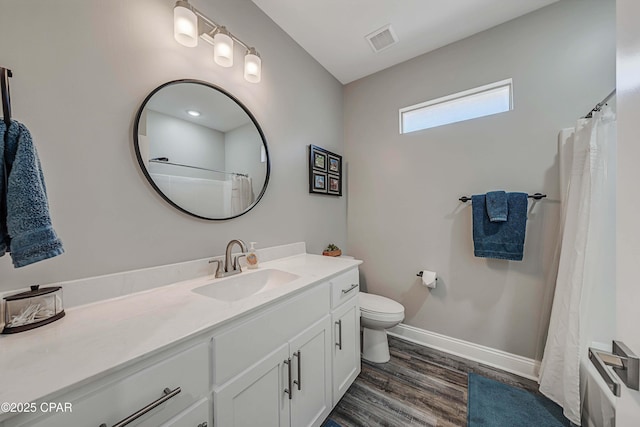 bathroom featuring hardwood / wood-style flooring, toilet, and vanity