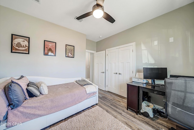 bedroom featuring ceiling fan, a closet, and light hardwood / wood-style floors