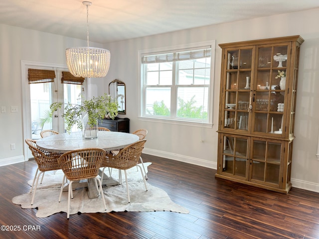 dining space with dark hardwood / wood-style floors and a notable chandelier