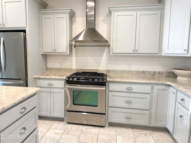 kitchen featuring light stone countertops, appliances with stainless steel finishes, backsplash, and wall chimney exhaust hood