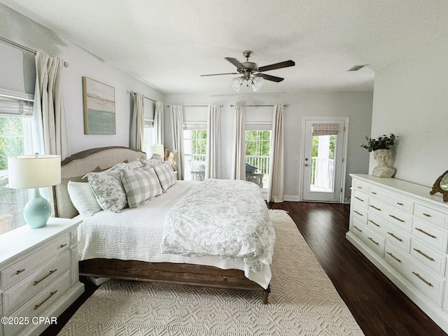 bedroom with multiple windows, access to exterior, dark hardwood / wood-style floors, and ceiling fan