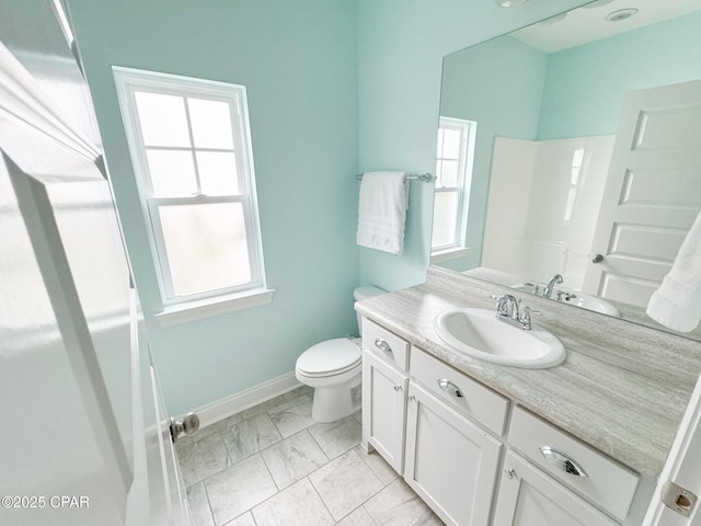 bathroom with vanity, a wealth of natural light, and toilet