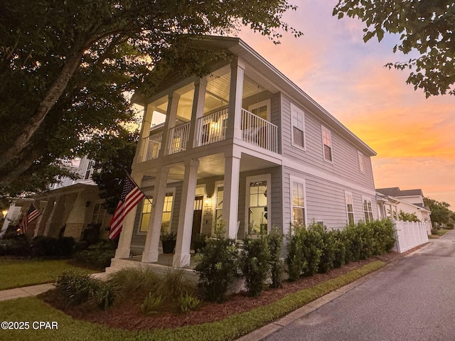 property exterior at dusk featuring a balcony