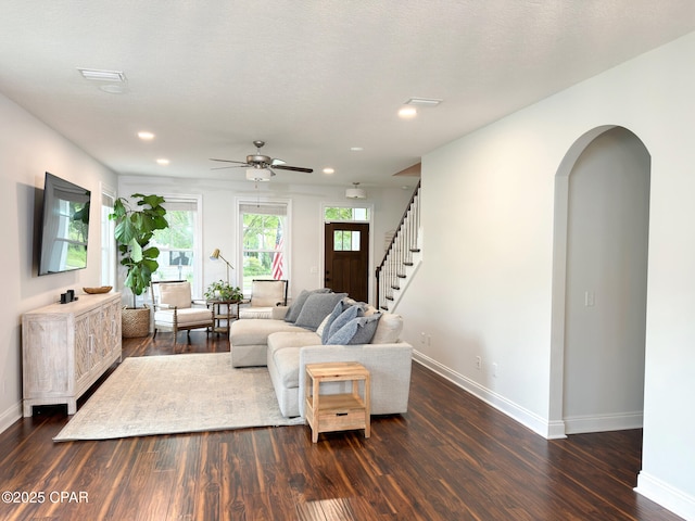 living room featuring ceiling fan and dark hardwood / wood-style flooring