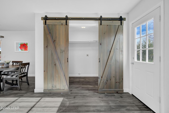 interior space with a barn door and dark wood-type flooring