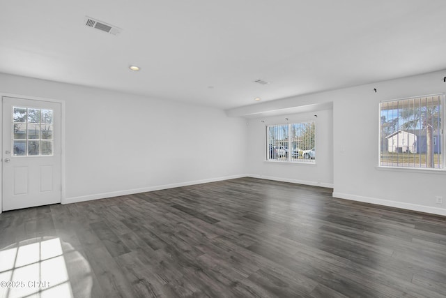 unfurnished room featuring dark hardwood / wood-style flooring and a wealth of natural light