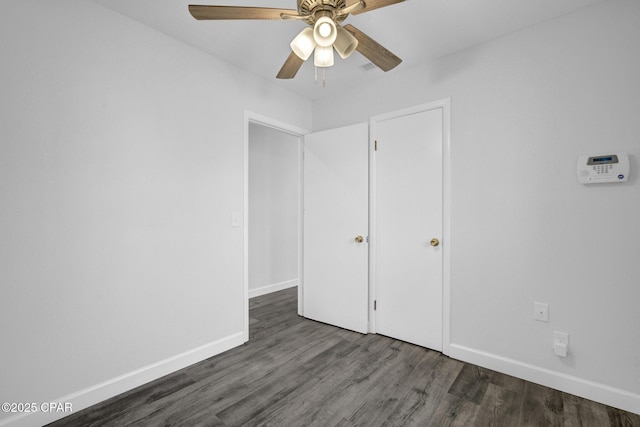 unfurnished bedroom featuring ceiling fan and dark hardwood / wood-style flooring