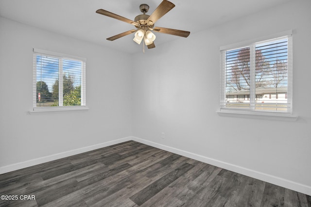 empty room featuring plenty of natural light, ceiling fan, and dark wood-type flooring