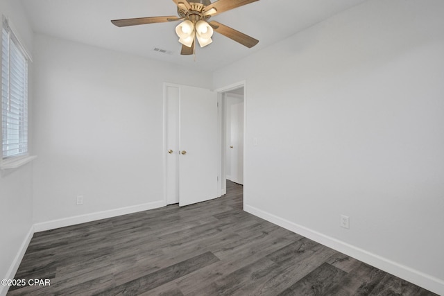 unfurnished room with ceiling fan and dark wood-type flooring