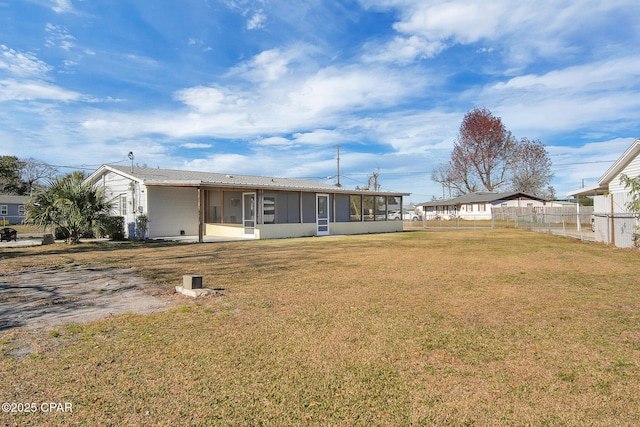 back of property featuring a sunroom and a yard