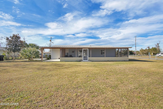 rear view of property featuring a sunroom and a yard