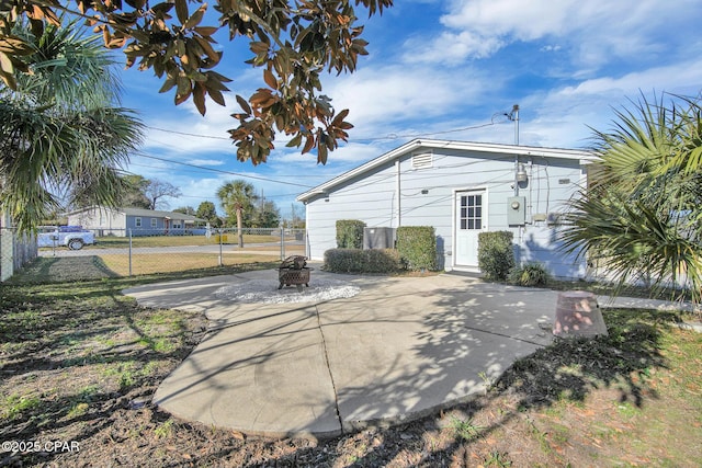 rear view of property with a patio and an outdoor fire pit