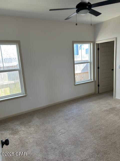 unfurnished room featuring ceiling fan and light colored carpet