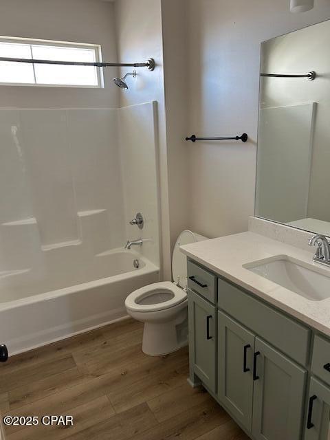 full bathroom with toilet, wood-type flooring, vanity, and bathing tub / shower combination