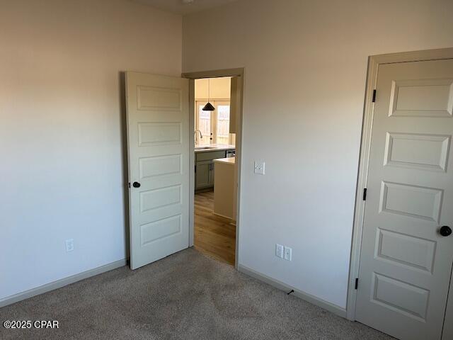 unfurnished bedroom with carpet flooring and sink