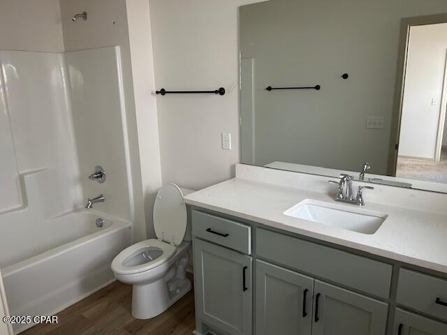 full bathroom with shower / bathing tub combination, vanity, toilet, and wood-type flooring