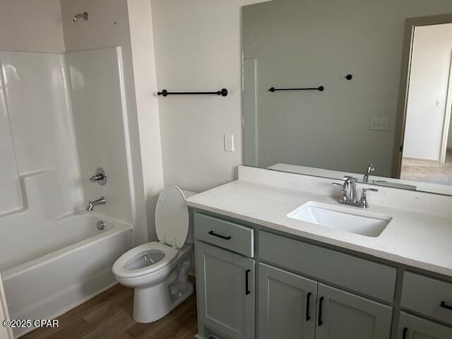 full bathroom with vanity, hardwood / wood-style floors, shower / tub combination, and toilet