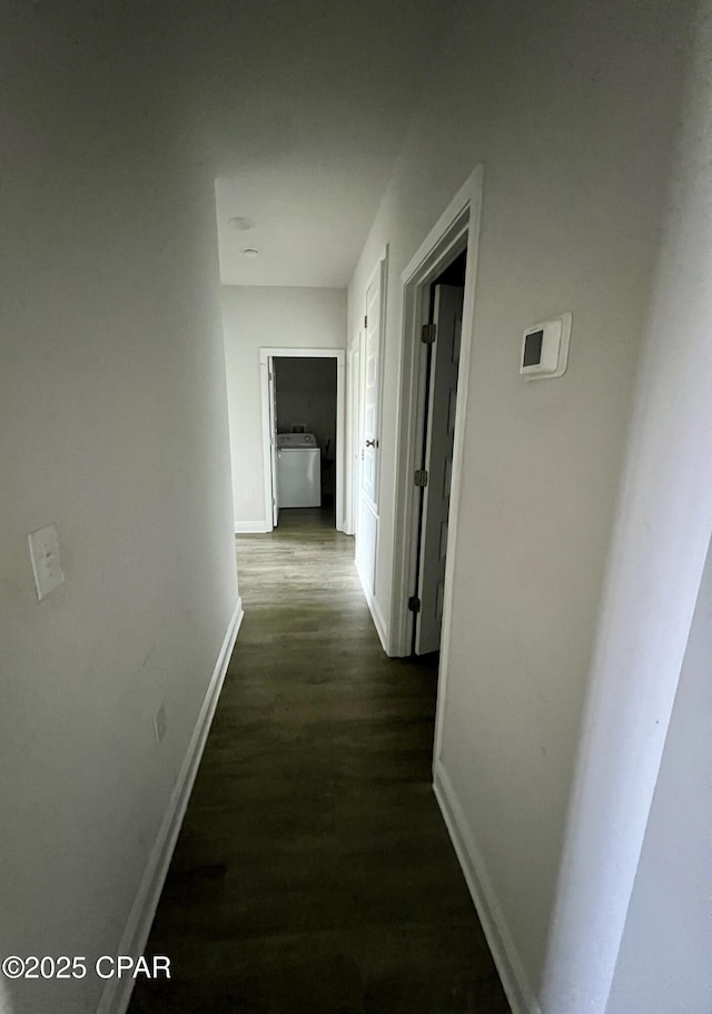 hall featuring washer / dryer and dark wood-type flooring