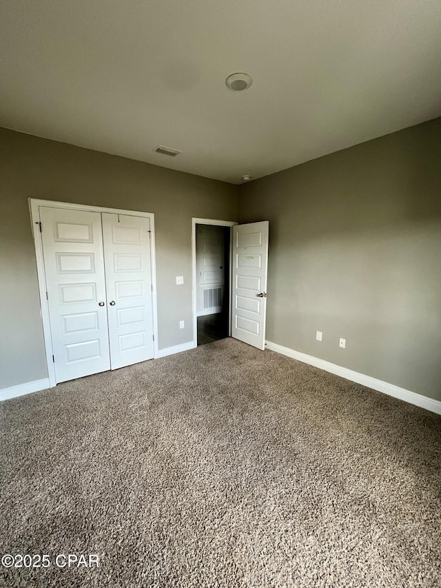 unfurnished bedroom featuring carpet flooring and a closet