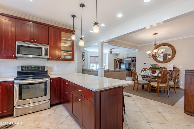 kitchen with pendant lighting, stainless steel appliances, ornamental molding, kitchen peninsula, and ornate columns